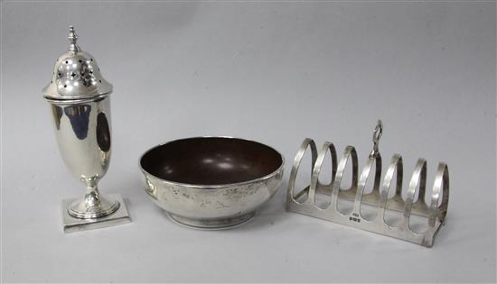 A George V silver mounted mazer bowl, a silver seven bar toastrack and a sterling silver sugar caster.